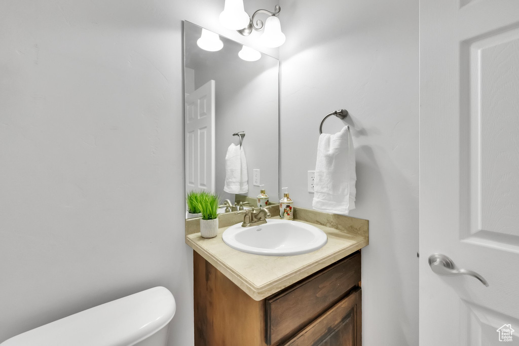 Half bathroom featuring vanity and toilet