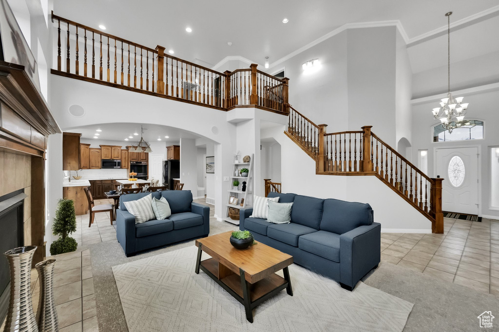 Living area with recessed lighting, arched walkways, a high ceiling, and stairs