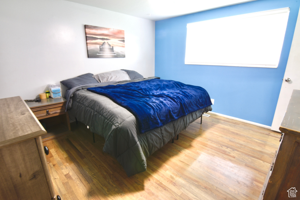 Bedroom with wood finished floors and baseboards