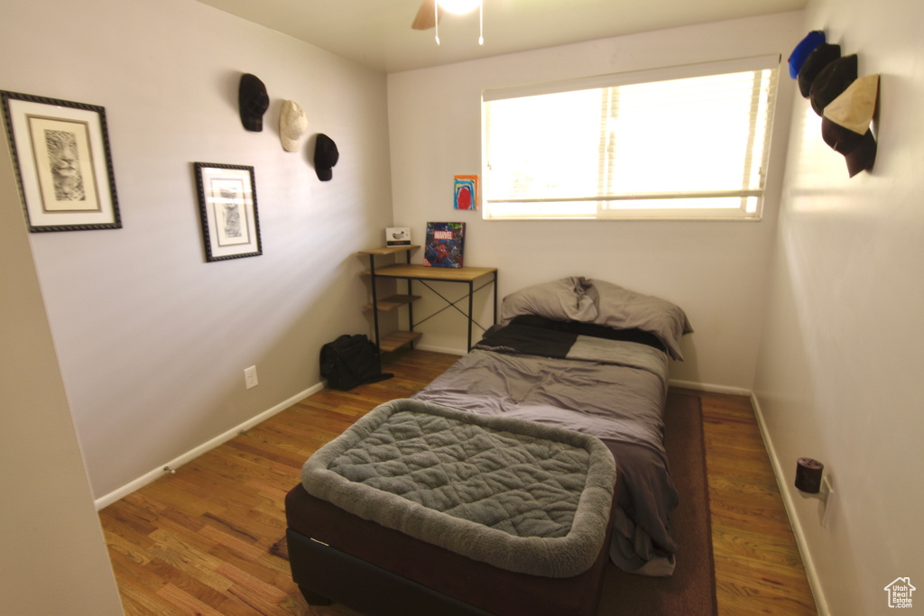 Bedroom featuring baseboards, wood finished floors, and a ceiling fan