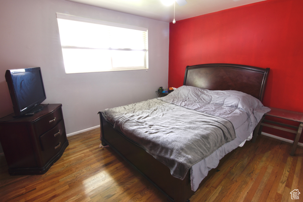 Bedroom with wood finished floors and baseboards