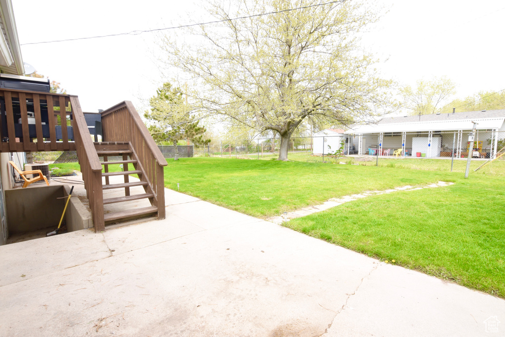 View of yard with fence, stairway, and a patio