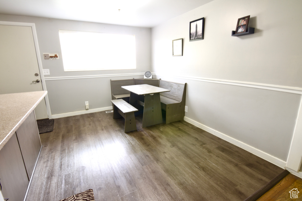 Dining area featuring baseboards and dark wood-type flooring