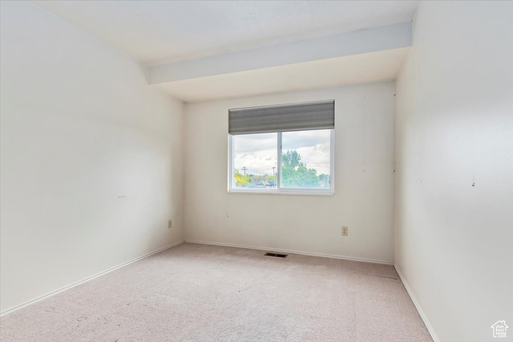 Unfurnished room with visible vents, baseboards, and light colored carpet