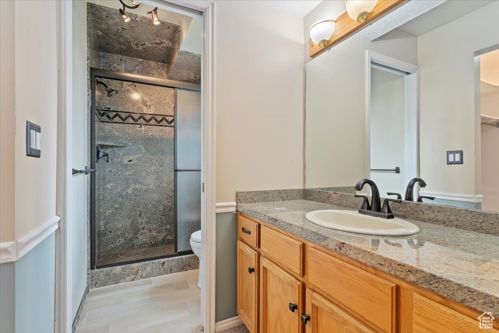 Full bath with vanity, toilet, and a stall shower