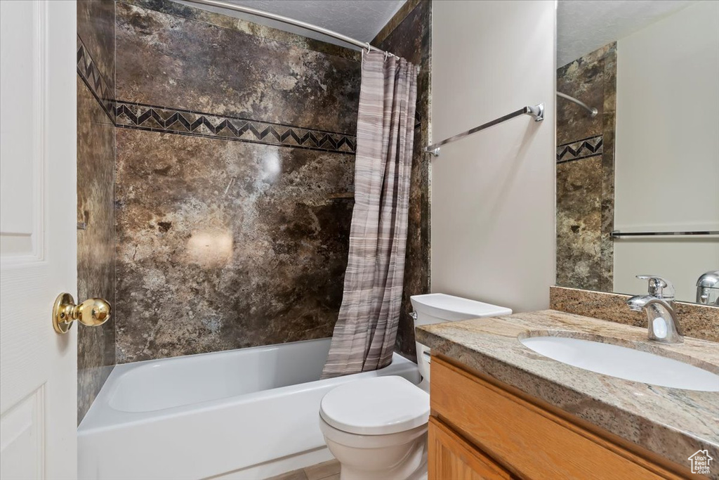 Full bathroom with vanity, toilet, and shower / bath combination with curtain