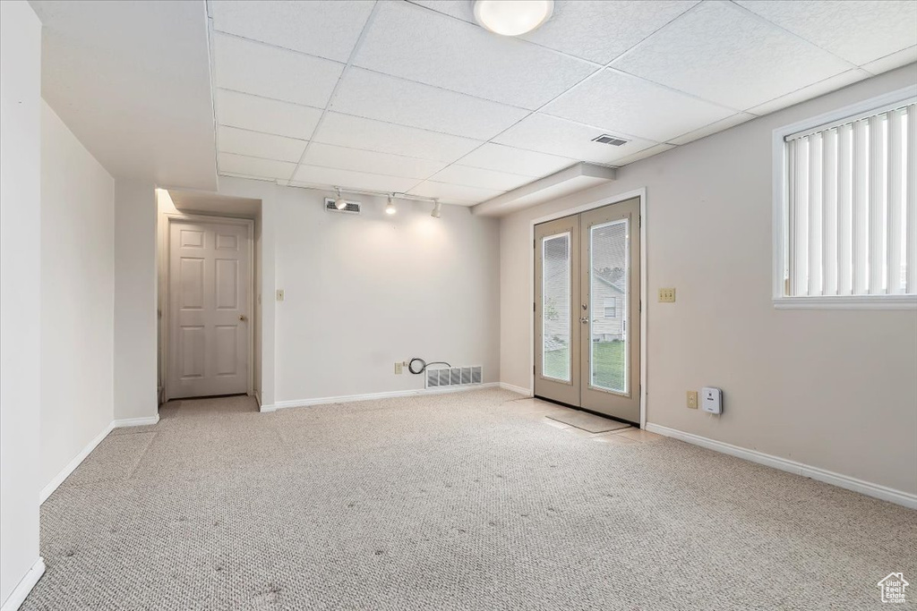 Spare room featuring visible vents, carpet, and a drop ceiling