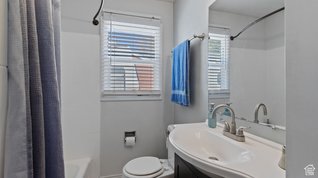 Full bathroom featuring vanity, shower / bathtub combination with curtain, and toilet