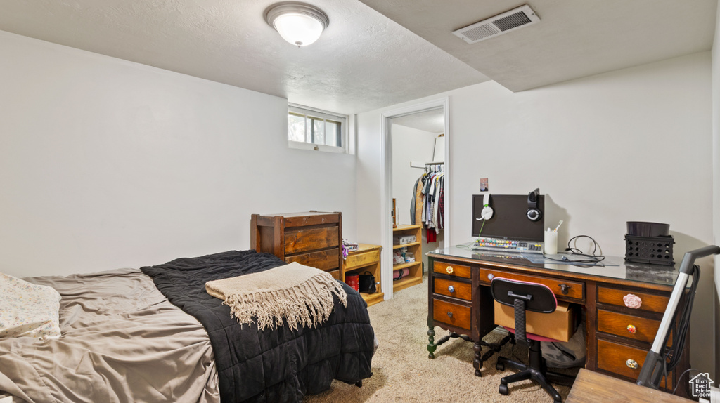Carpeted bedroom with visible vents, a spacious closet, and a closet