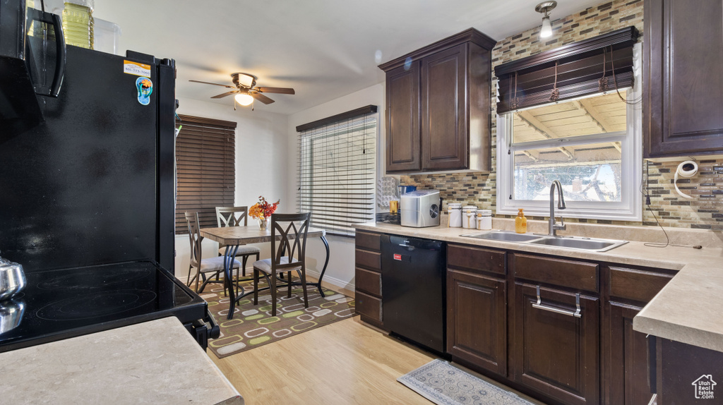 Kitchen featuring a ceiling fan, decorative backsplash, a sink, and black appliances