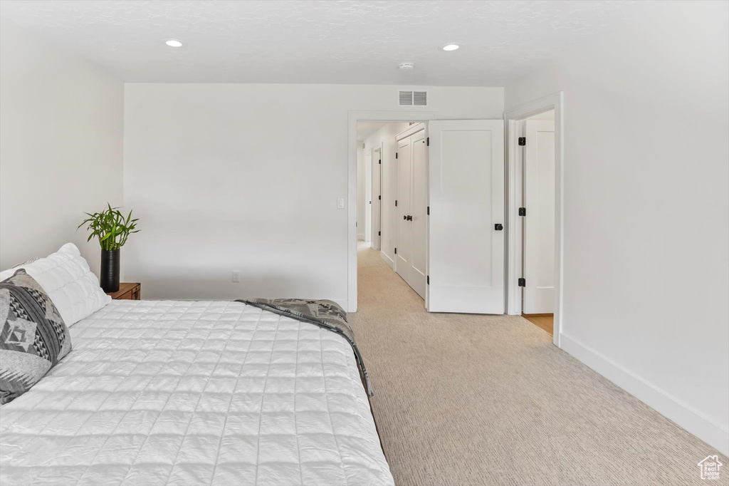 Bedroom featuring visible vents, recessed lighting, baseboards, and light colored carpet