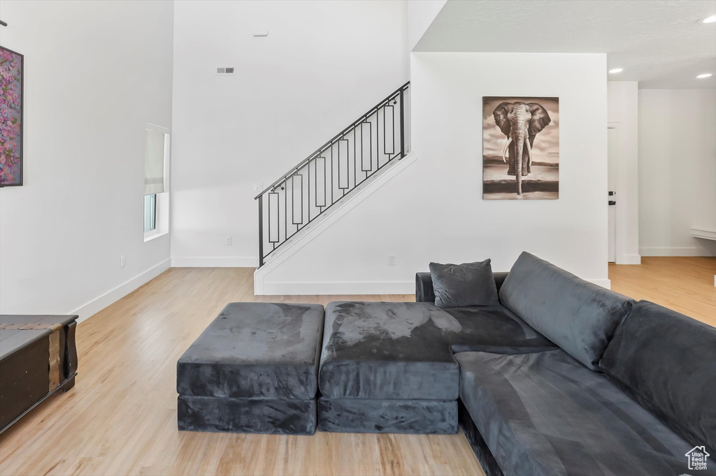 Living room featuring stairs, baseboards, and wood finished floors