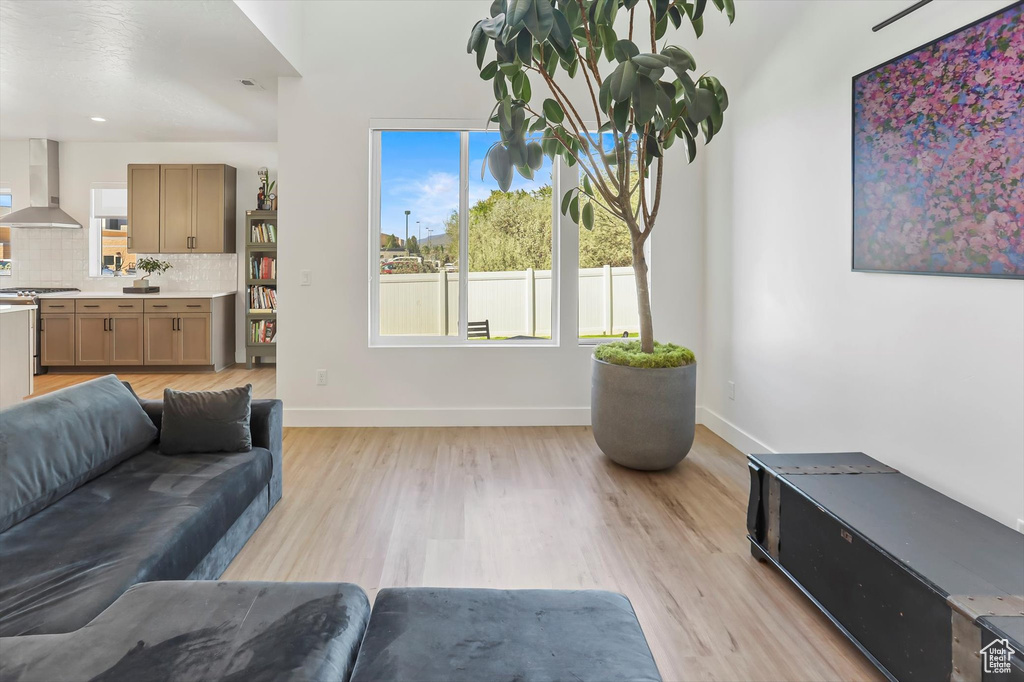 Living area featuring light wood-style floors, baseboards, and a wealth of natural light