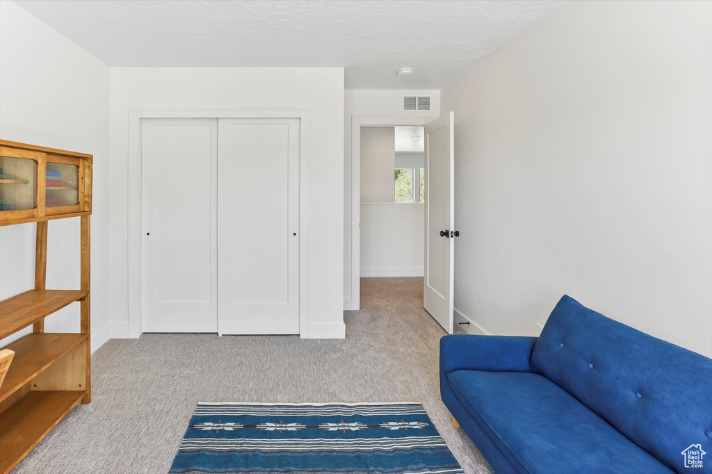 Living area featuring visible vents, baseboards, and carpet floors