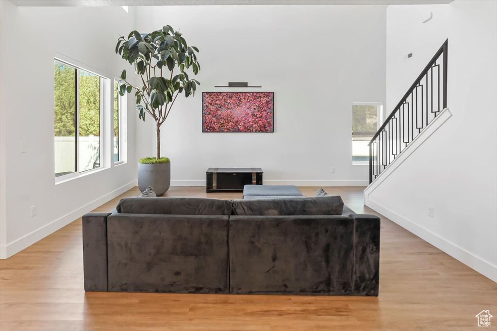 Living area featuring baseboards, stairway, and light wood-type flooring