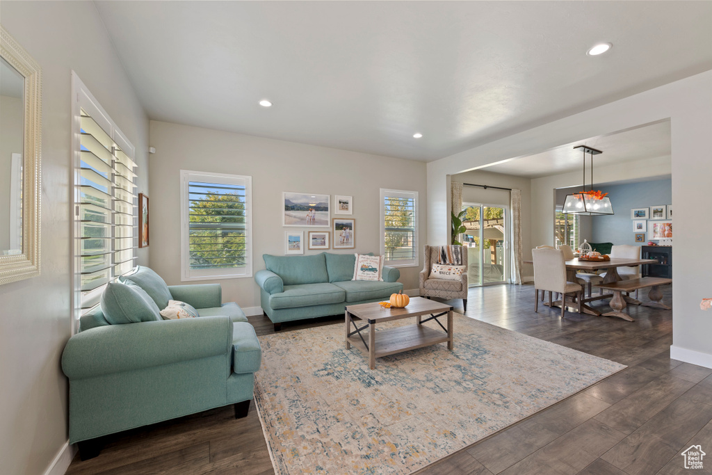Living room featuring recessed lighting, dark wood-style floors, and plenty of natural light