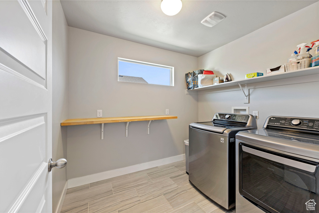 Laundry area featuring washer and dryer, laundry area, visible vents, and baseboards