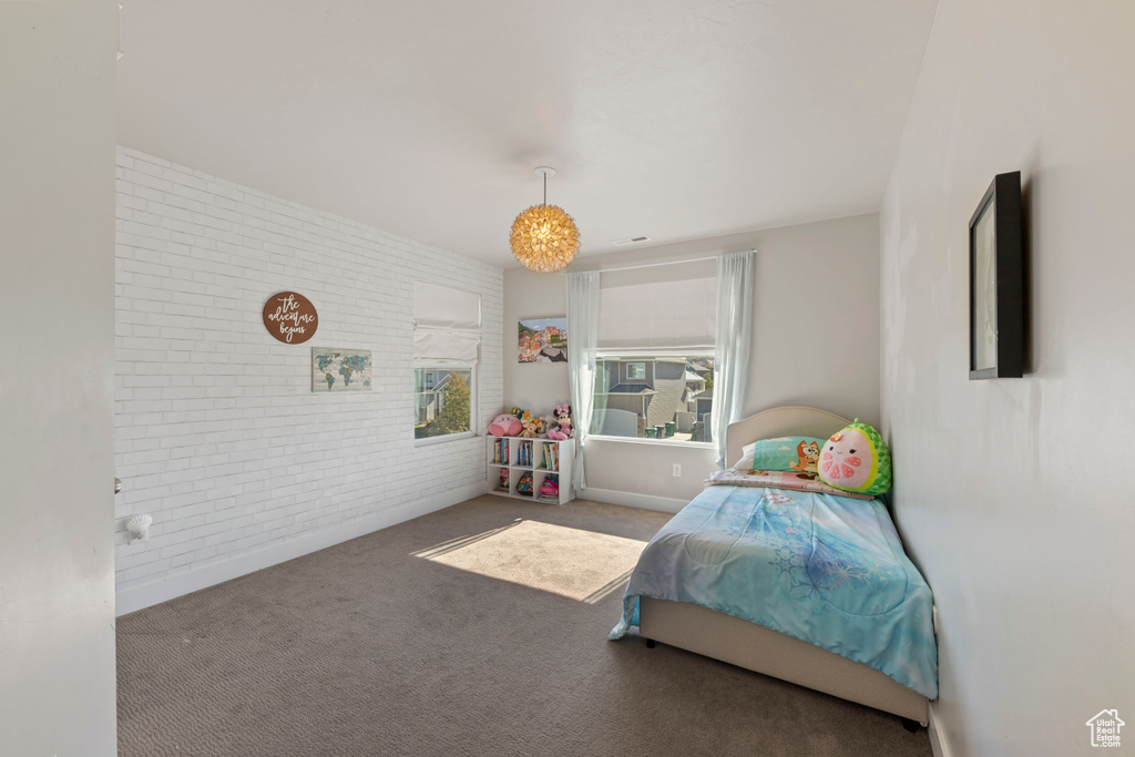 Bedroom featuring carpet floors and brick wall