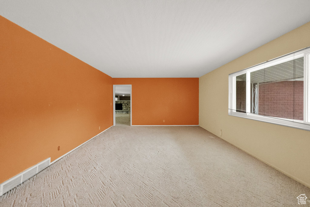 Spare room featuring carpet flooring and visible vents