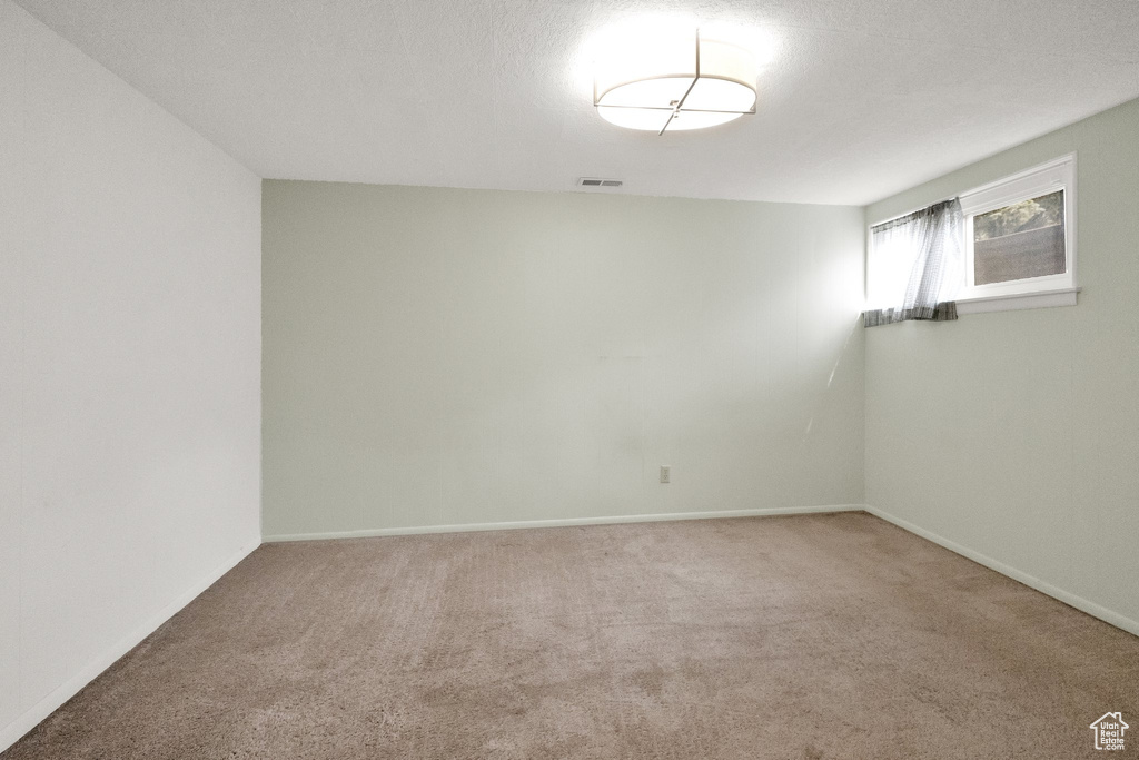 Spare room with carpet flooring, baseboards, and visible vents