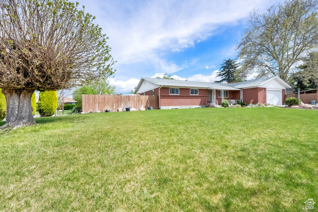 Exterior space with fence, a front yard, and a garage