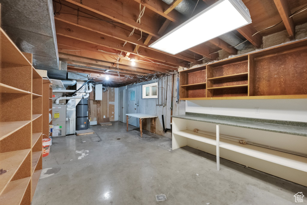 Unfinished basement featuring water heater and heating unit