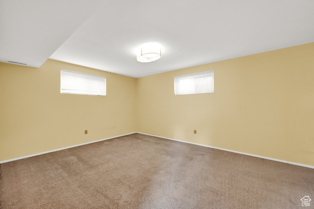 Empty room featuring baseboards, carpet flooring, and visible vents