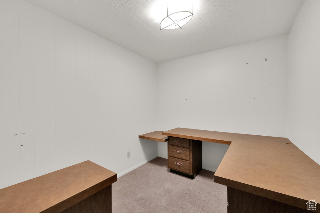Unfurnished office with light colored carpet and built in study area