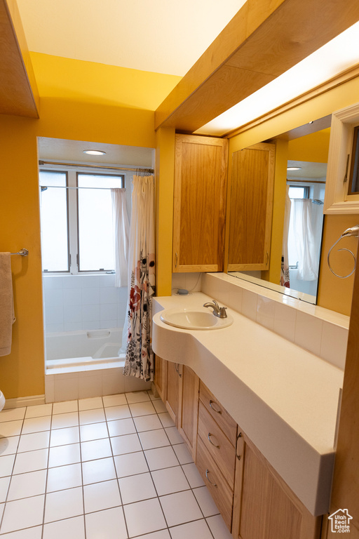 Full bath with toilet, tile patterned floors, shower / tub combo with curtain, and vanity