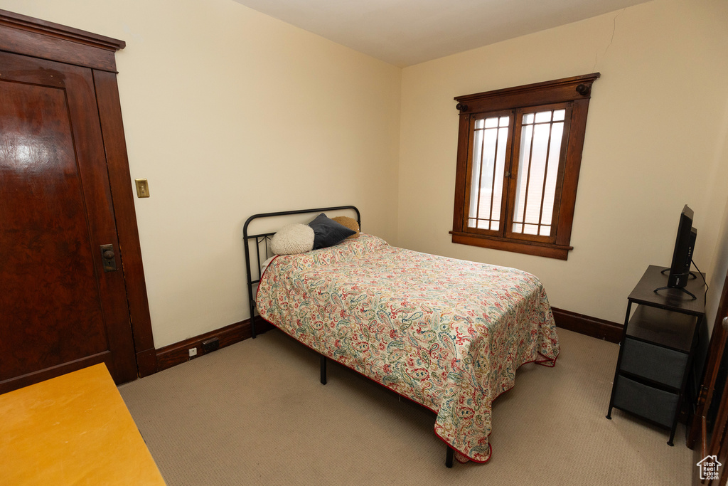 Bedroom featuring baseboards and light carpet