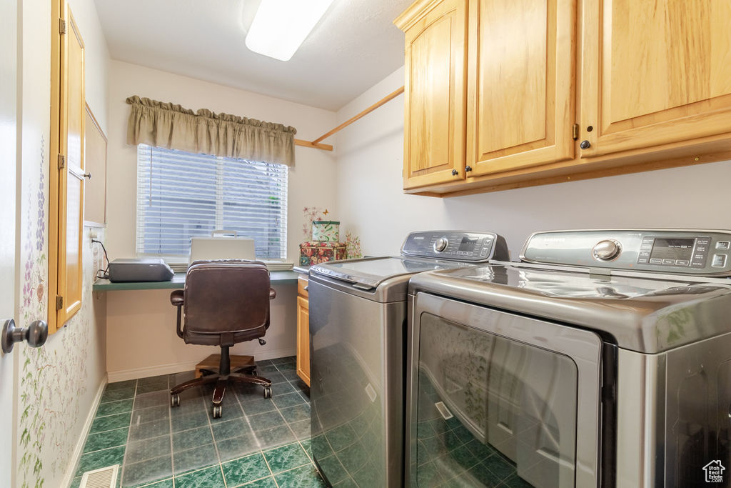 Laundry area featuring visible vents, cabinet space, baseboards, and washer and clothes dryer