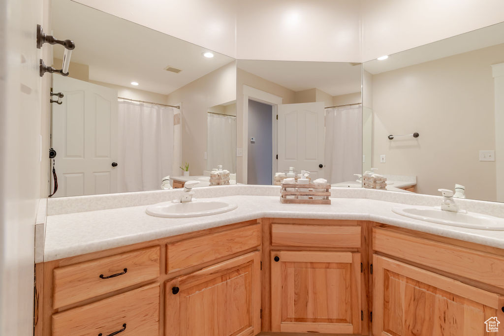 Bathroom featuring double vanity, a sink, and visible vents