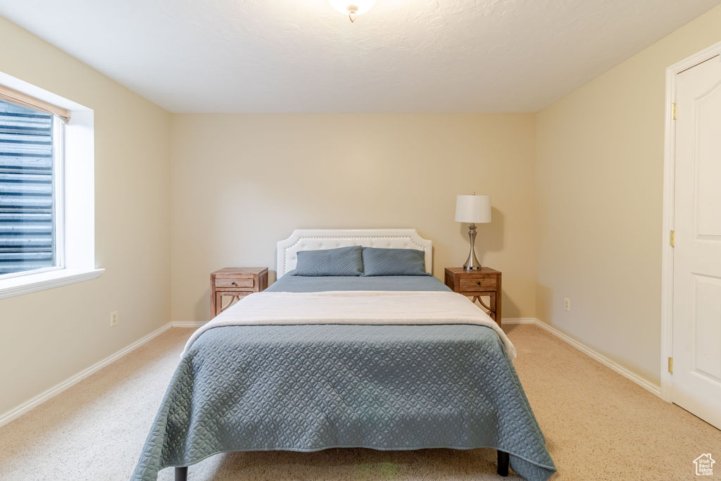Bedroom with baseboards and light carpet