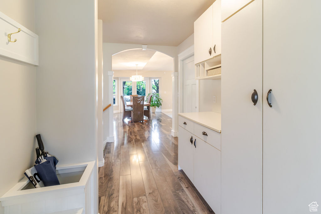 Hallway featuring dark wood-style floors and arched walkways