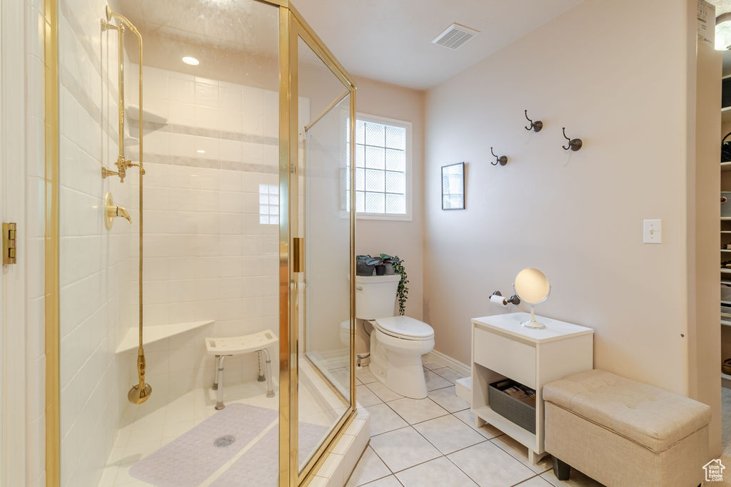 Bathroom featuring visible vents, a stall shower, toilet, and tile patterned flooring