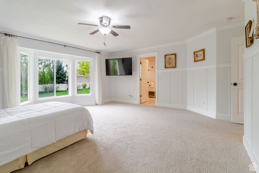 Bedroom with crown molding, a ceiling fan, and light colored carpet