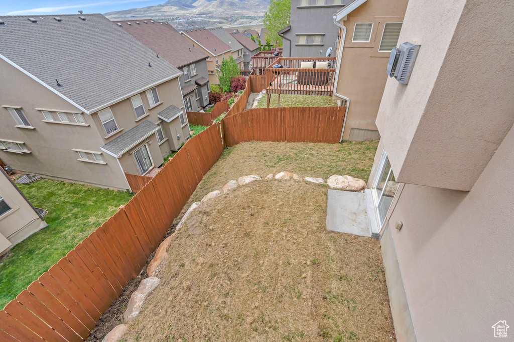 View of yard with a fenced backyard, a mountain view, and a residential view