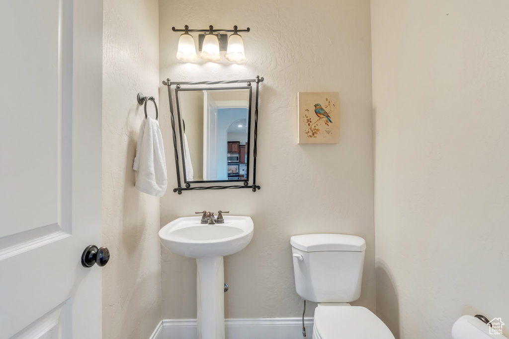 Half bathroom with toilet and a sink