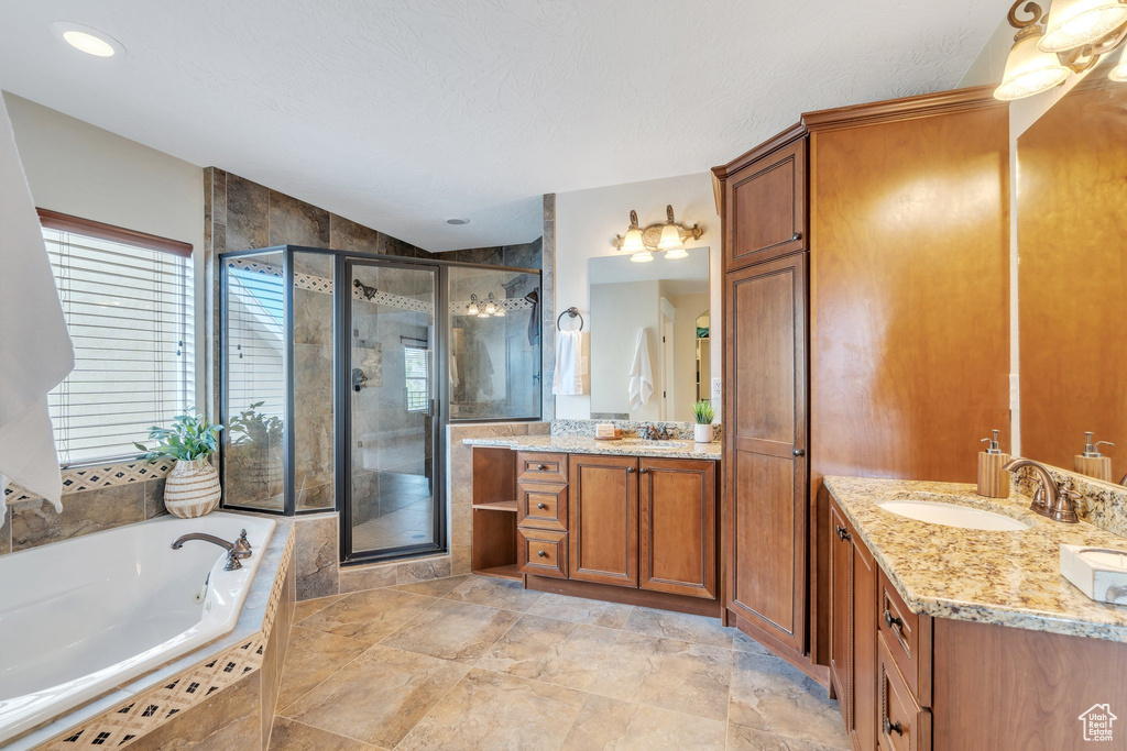 Full bath featuring vanity, a shower stall, and a garden tub