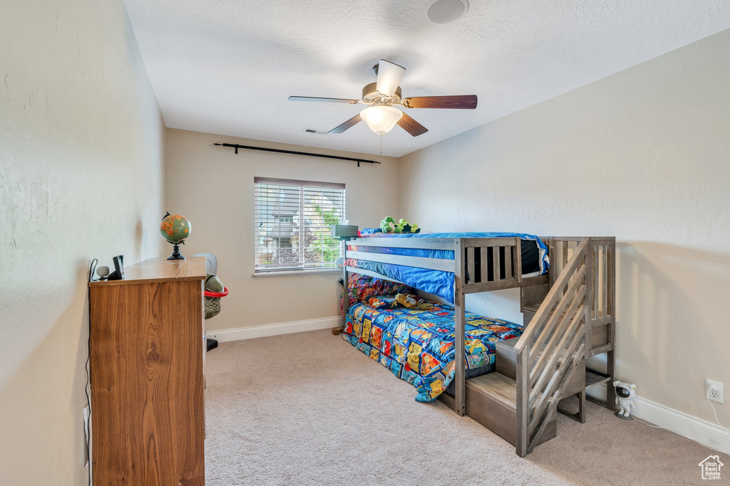 Bedroom featuring baseboards, ceiling fan, and carpet