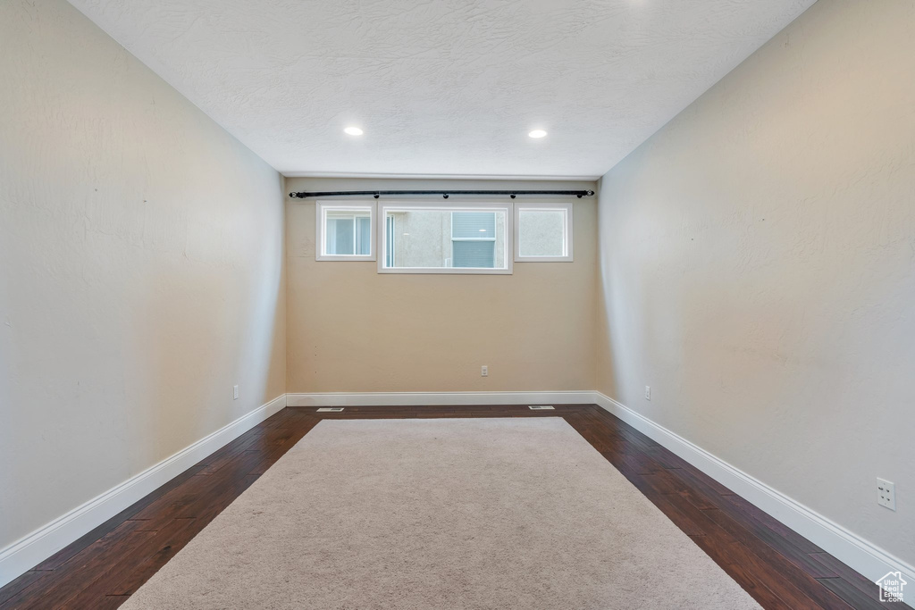 Unfurnished room featuring baseboards, recessed lighting, and dark wood-style flooring