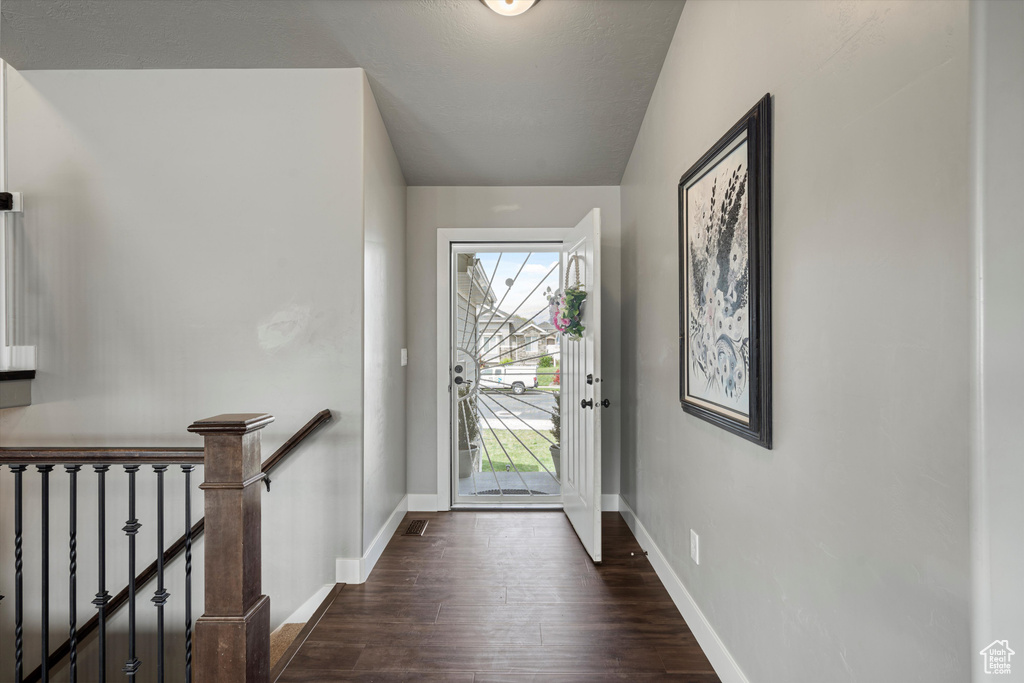 Foyer featuring baseboards and dark wood-style floors