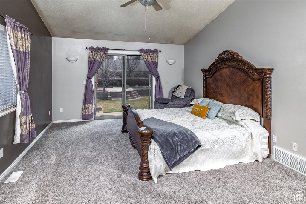 Carpeted bedroom with a ceiling fan, baseboards, visible vents, and lofted ceiling