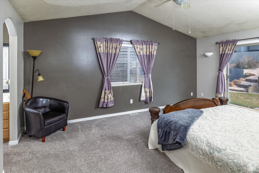 Bedroom with ceiling fan, arched walkways, vaulted ceiling, baseboards, and carpet flooring