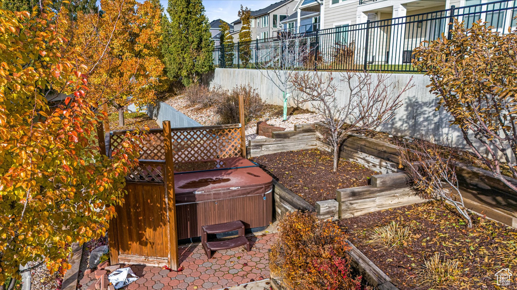 View of yard with a hot tub, fence, and a patio area