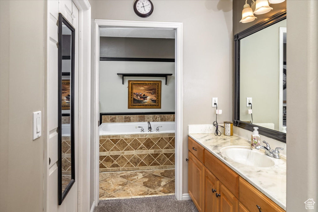 Bathroom featuring tile patterned floors, a bath, and vanity