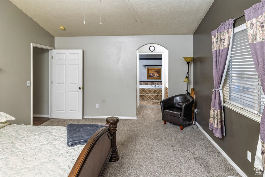 Bedroom featuring baseboards, carpet, attic access, and lofted ceiling