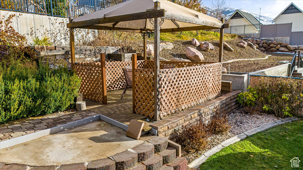 Exterior space featuring a gazebo, a patio area, and fence