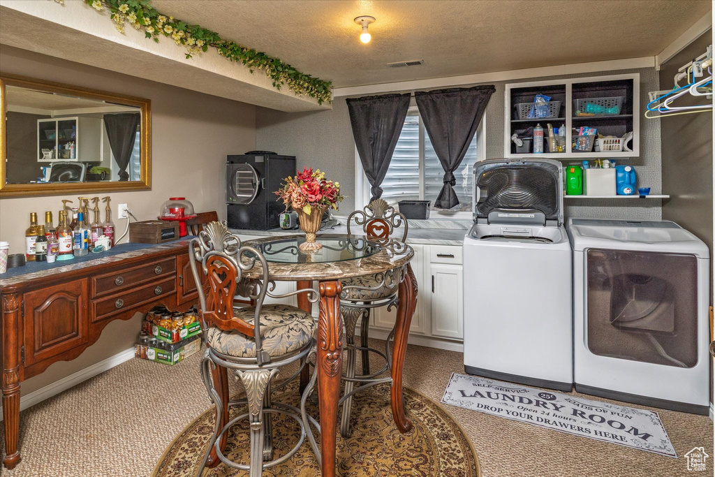 Laundry area with visible vents, a textured ceiling, washing machine and clothes dryer, carpet flooring, and cabinet space