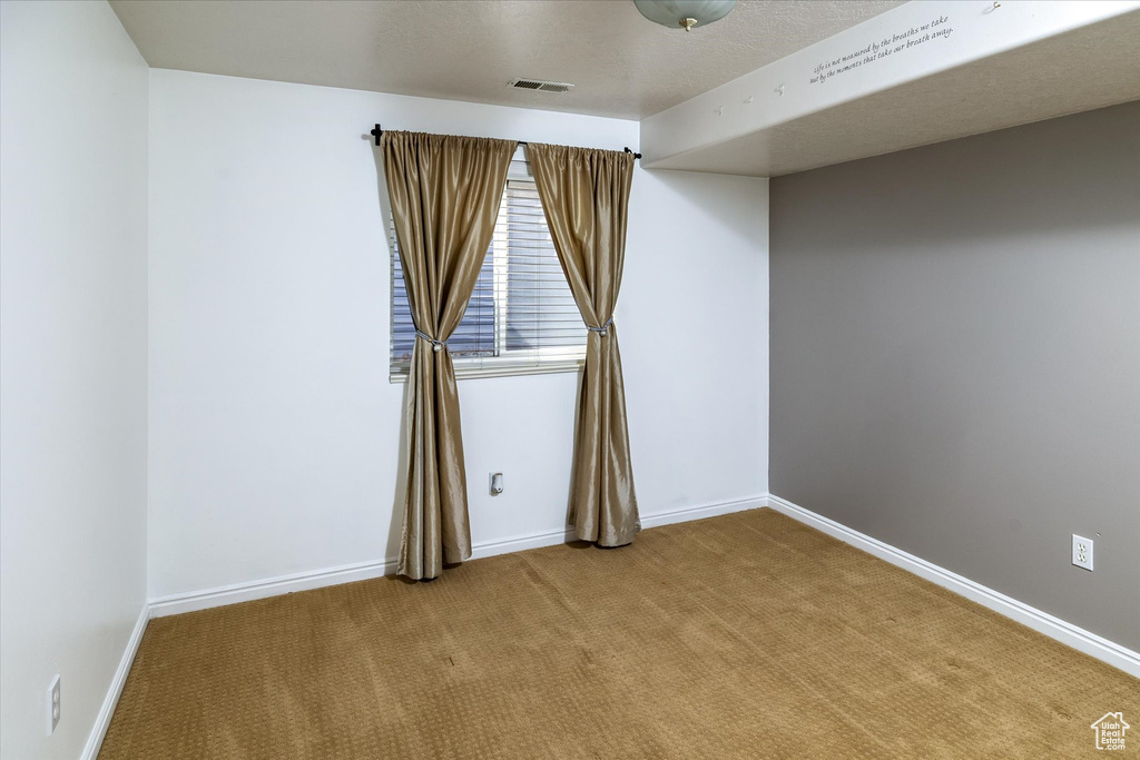 Spare room with visible vents, baseboards, and carpet floors